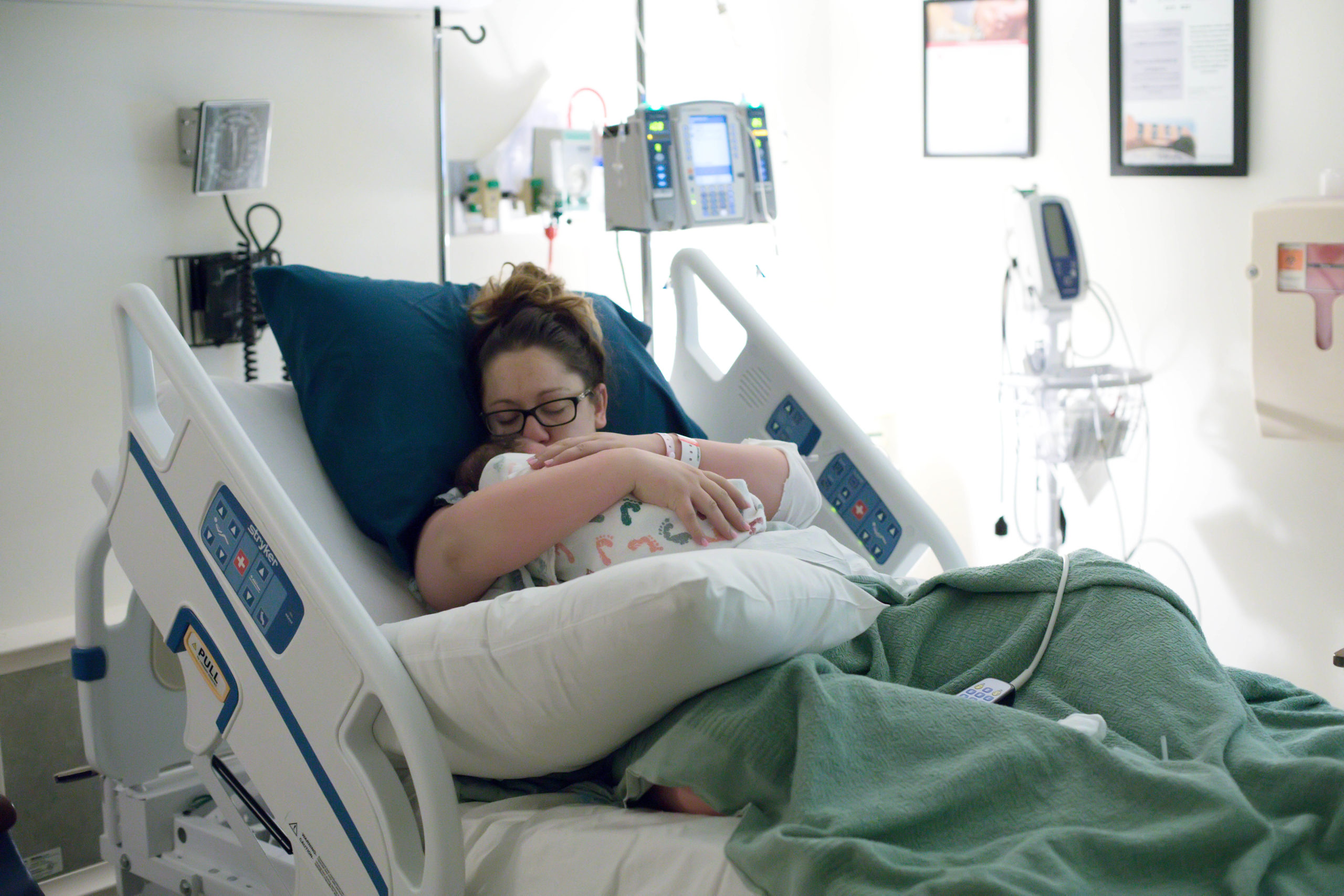 Mother holding baby in a hospital bed